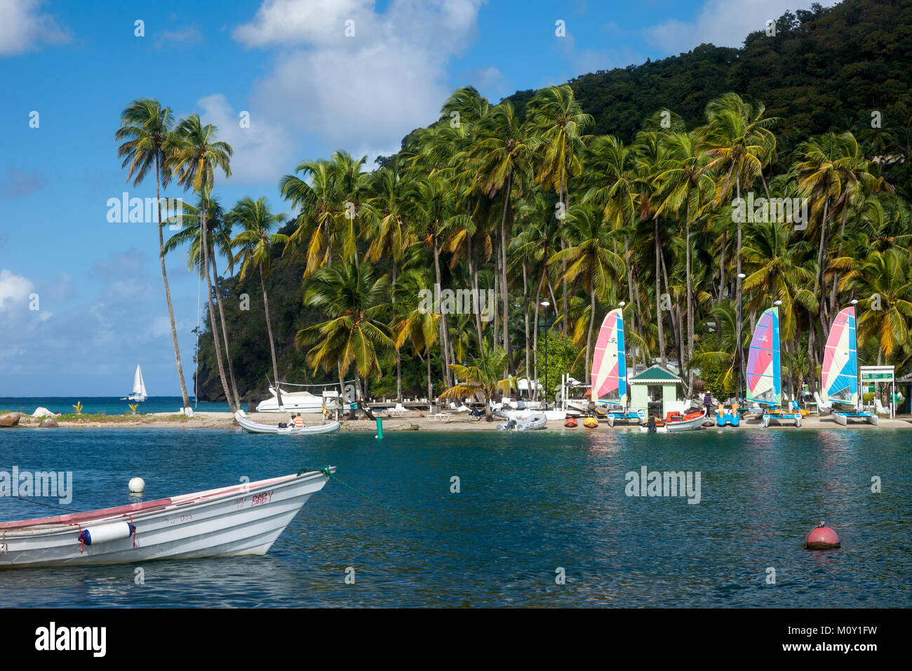 Barche e palme lungo la spiaggia di Marigot Bay, St Lucia, West Indies Foto Stock