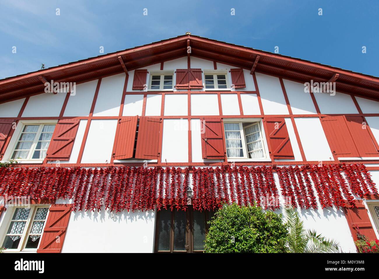 Francia,Pirenei Atlantiques,Pays Basque,Espelette,pepe essiccamento sulla facciata di una casa tradizionale Foto Stock