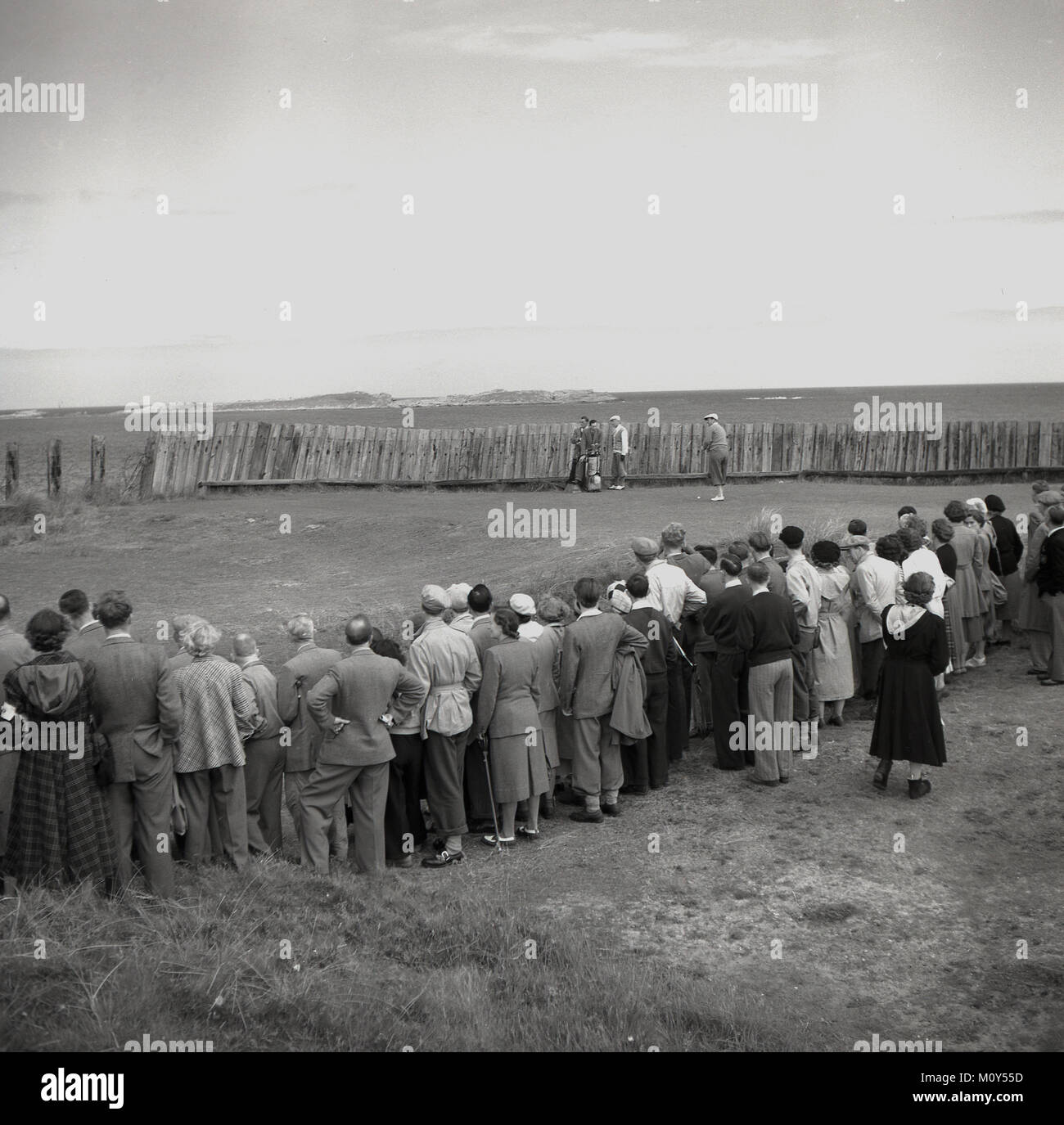 1951, foto storiche, gli spettatori a guardare South African golfista Bobby Locke - indossa il suo plus-fours o kniccurbockers e tappo piatto - circa al tee off sulle maglie della Royal Portrush Golf in Co Antirm, Irlanda del Nord nel British Open Championship. Foto Stock