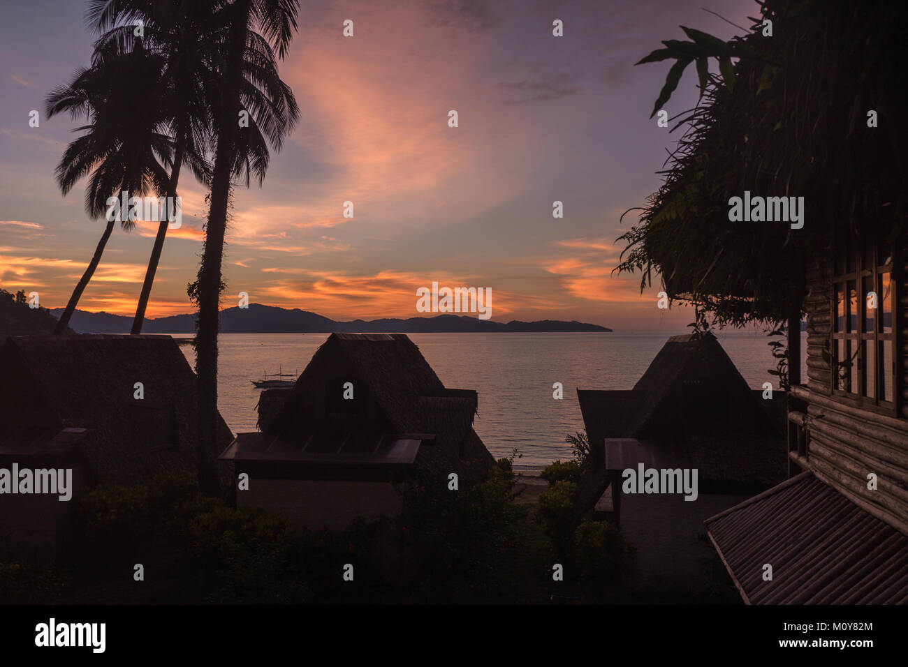Vista del tramonto dalla profonda Oro Resort sulla spiaggia di Port Barton, Filippine Foto Stock