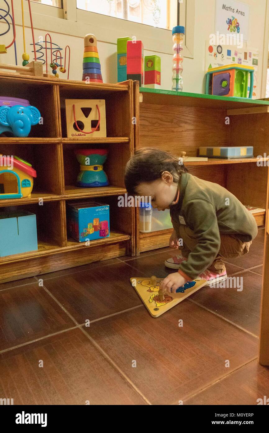 Due anno vecchia ragazza giocare con puzzle in pre-scuola Foto Stock
