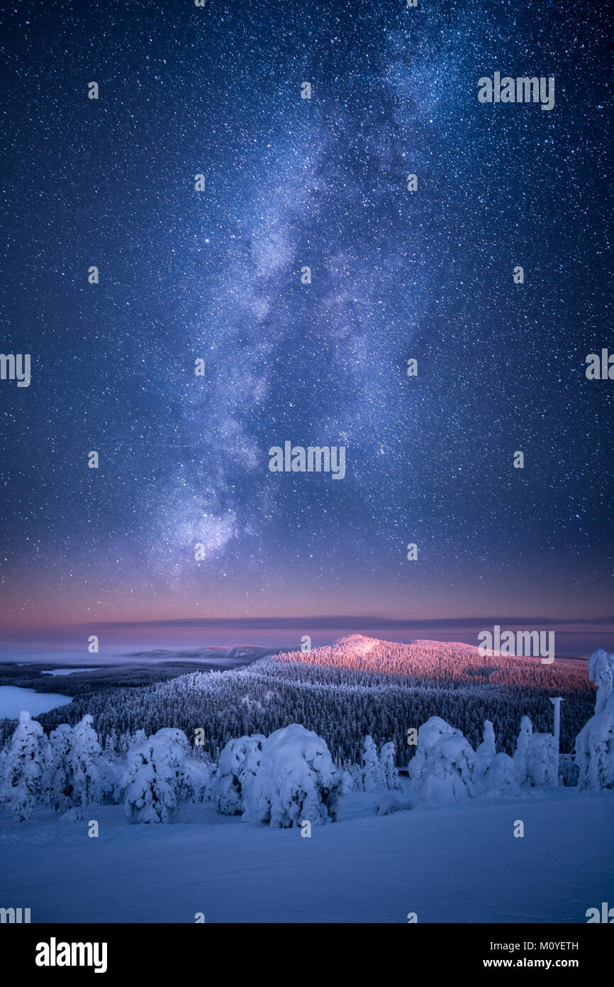 Vista artistica del paesaggio finlandese in inverno con la Via Lattea risplende sul cielo a Ruka, Finlandia Foto Stock