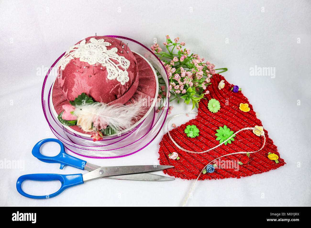 Cucito e artigianato per il giorno di San Valentino - Rosa hat pin cuscino e sissors con nastro e fiori e un tessuto rosso cuore Foto Stock