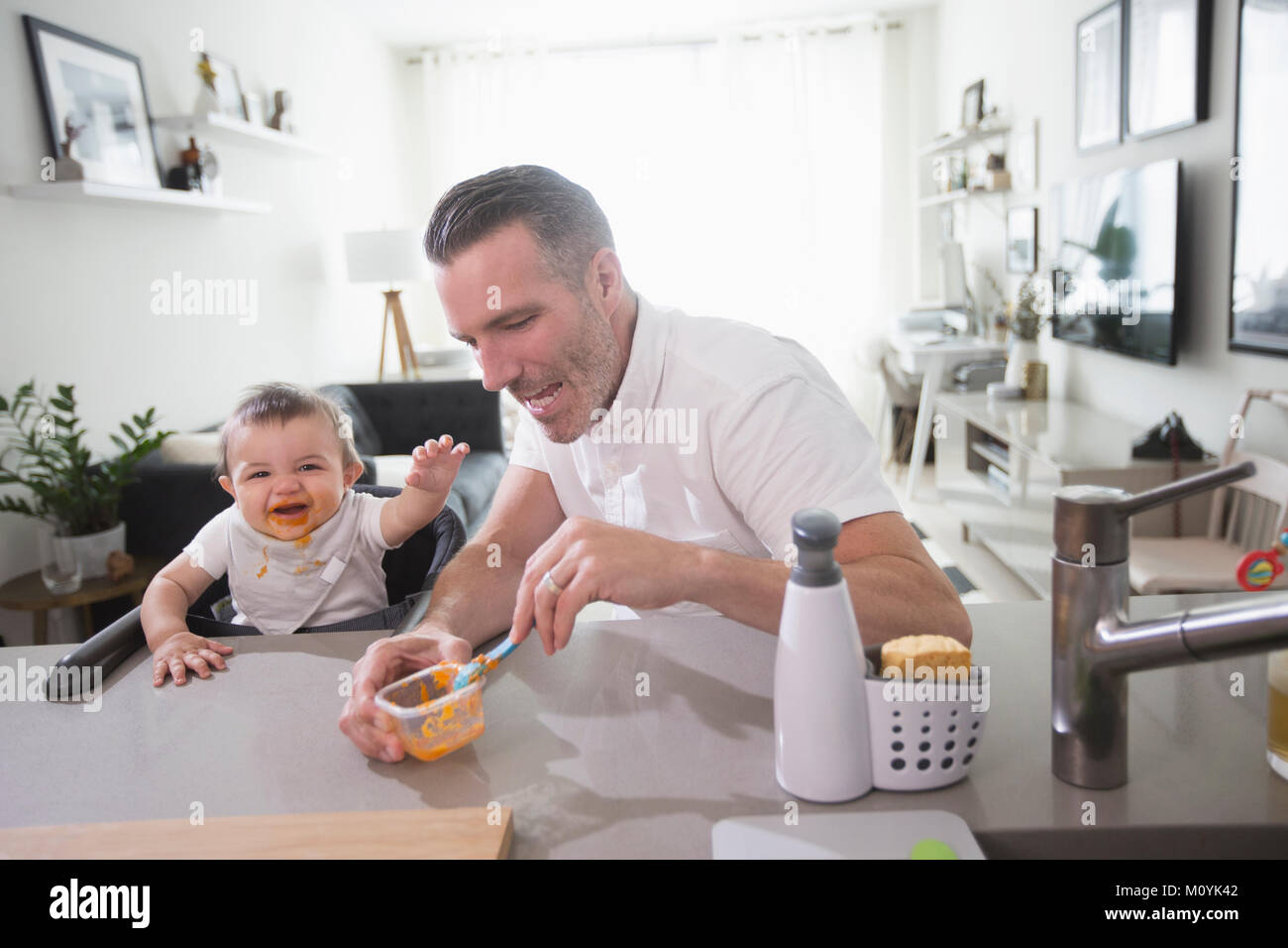 Padre alimentare happy baby figlio Foto Stock