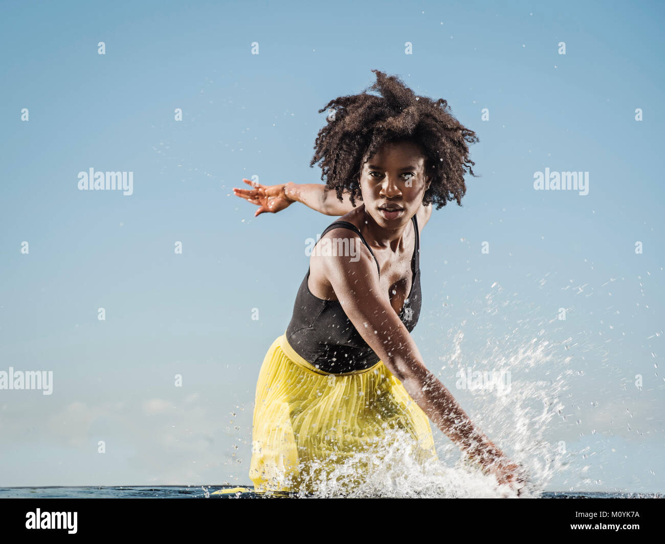 Nero donna schizzi in acqua Foto Stock