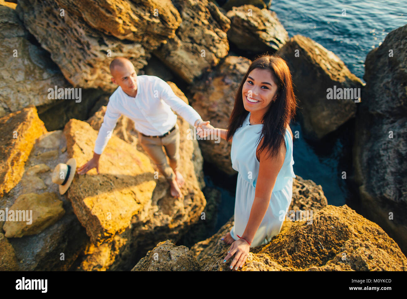 Coppia caucasica arrampicata sulle rocce a beach Foto Stock