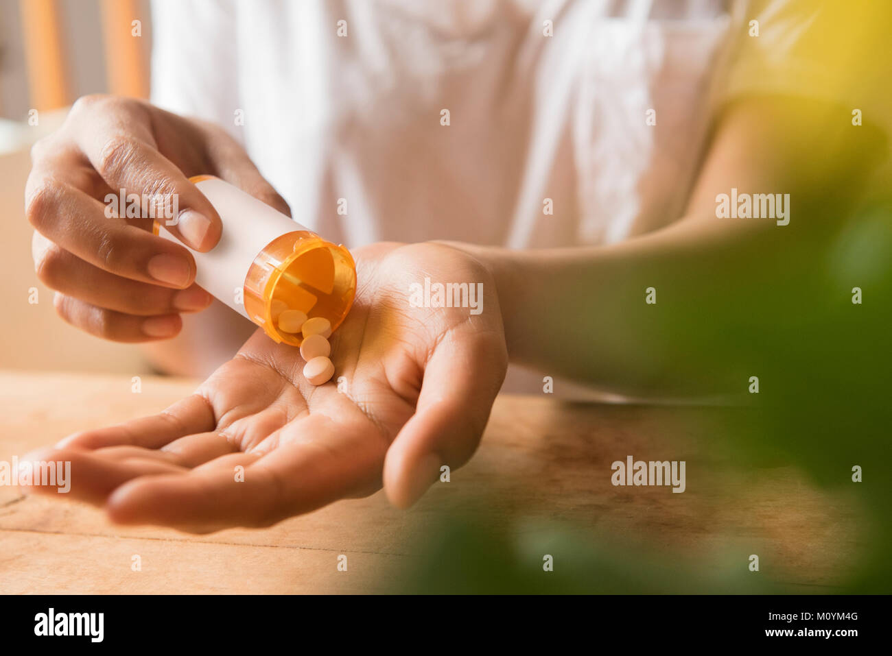 Mani di African American donna azienda medicina di prescrizione Foto Stock