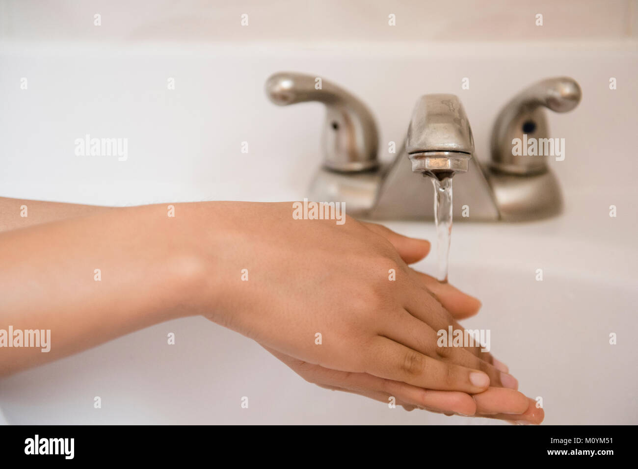 African American donna mani di lavaggio con acqua Foto Stock