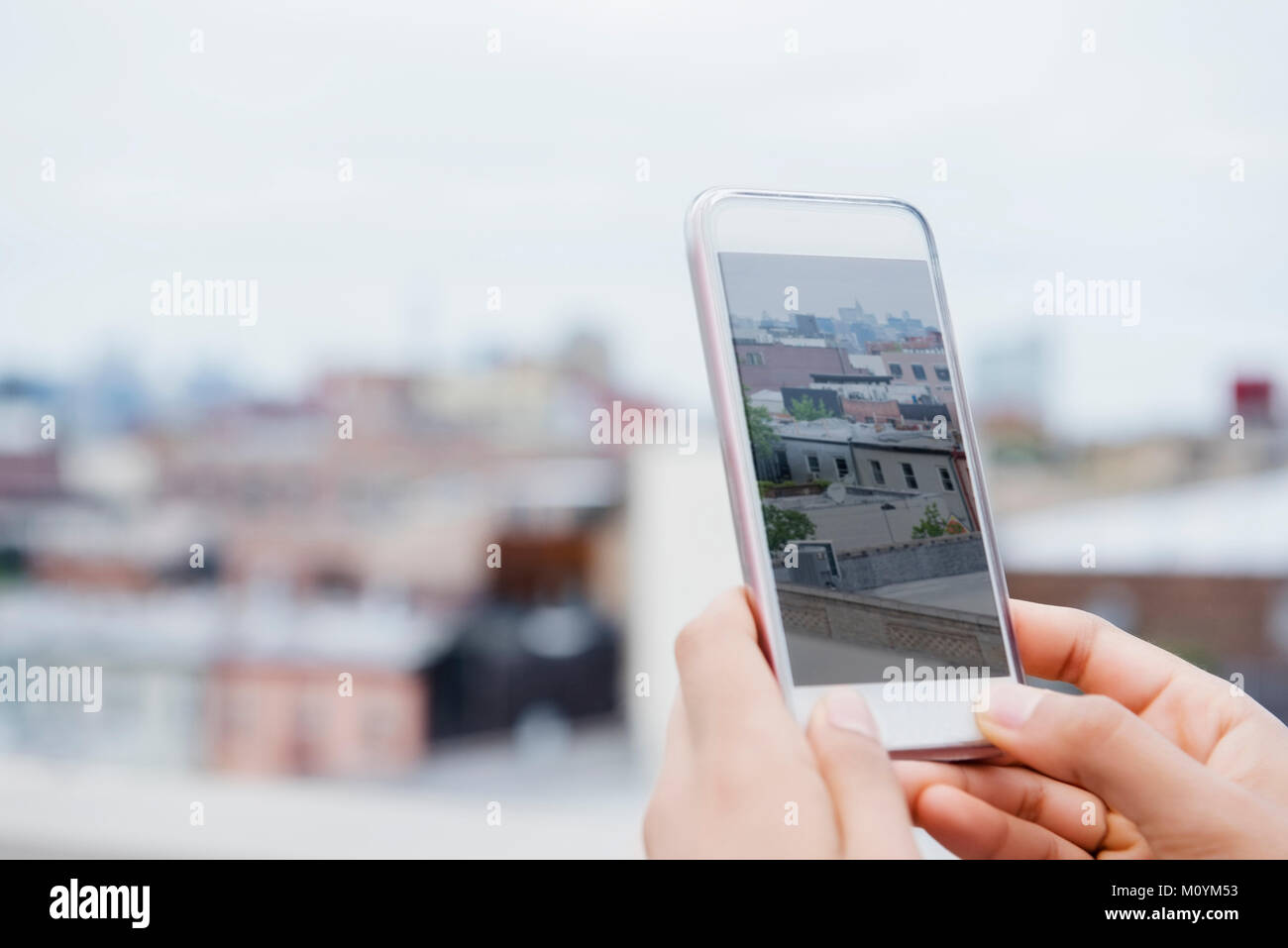 Mani di African American donna fotografare cityscape con un telefono cellulare Foto Stock