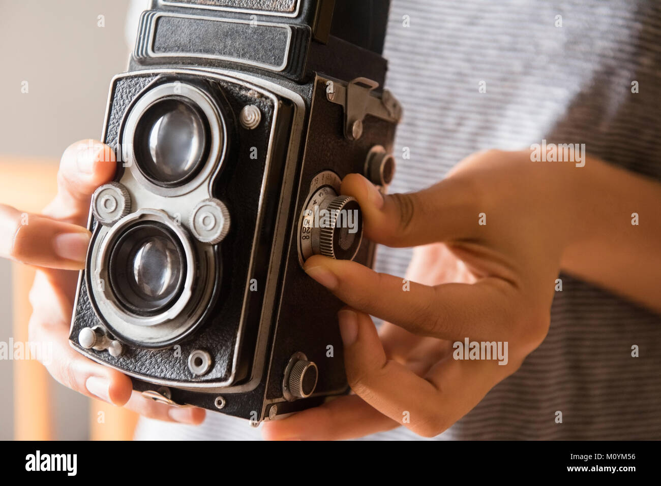 Mani di African American donna usando un vecchio stile fotocamera Foto Stock