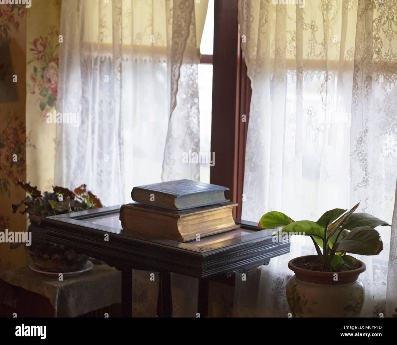 Libri antichi su una scrivania in esposizione accanto a una finestra in Thorpe House interno, casa vittoriana costruito nel 1886 e restaurato Foto Stock