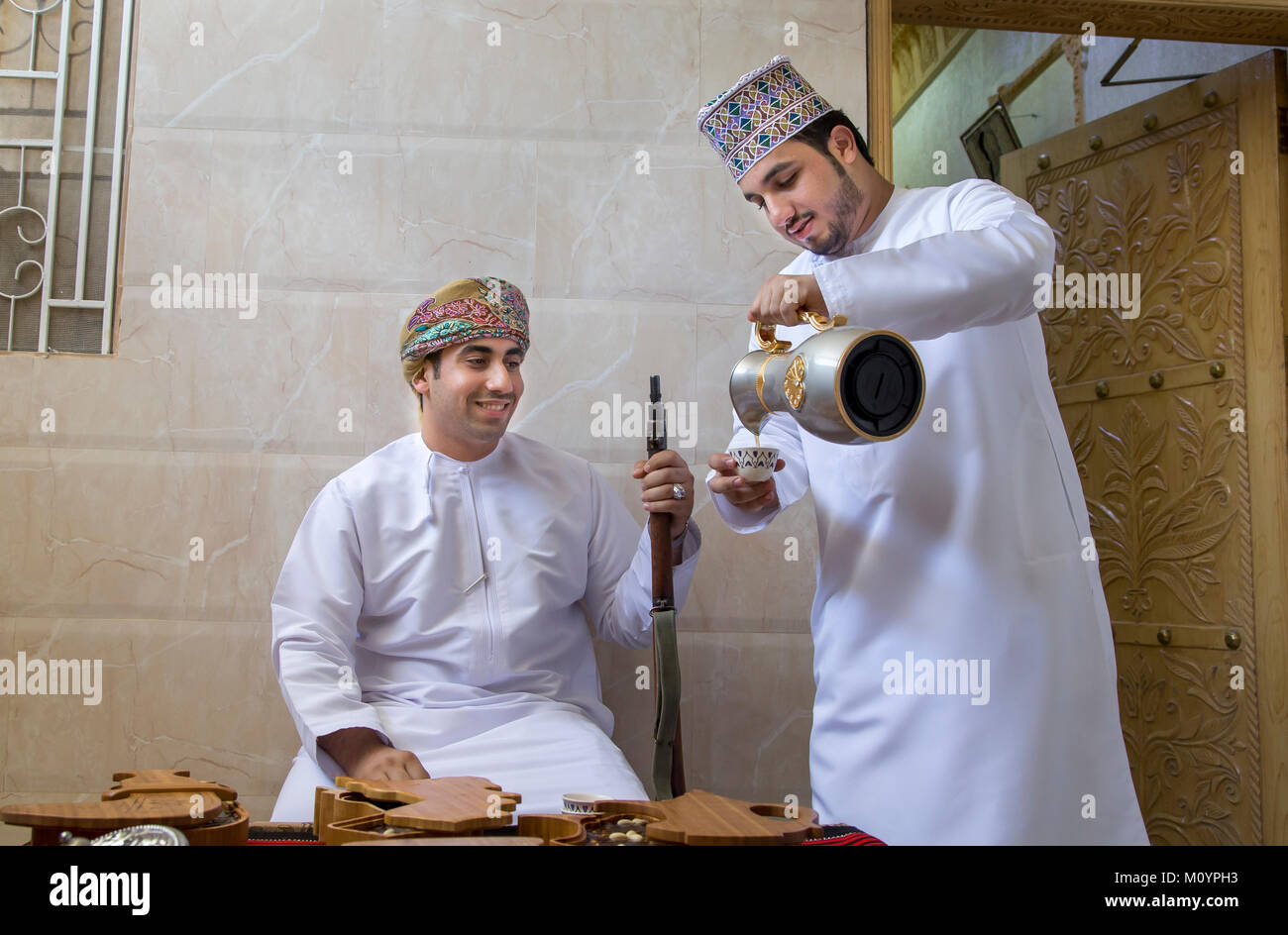 Nizwa, Oman, 26 Maggio 2016: omani uomo che serve caffè tradizionale chiamato qawa a un altro uomo dell'Oman Foto Stock