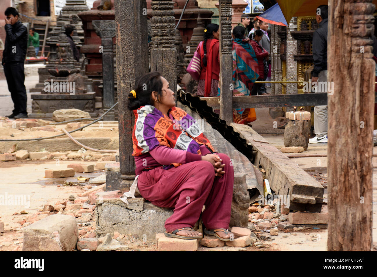 Donna presso il Tempio delle Scimmie di pensare e in seduta, Kathmandu Foto Stock