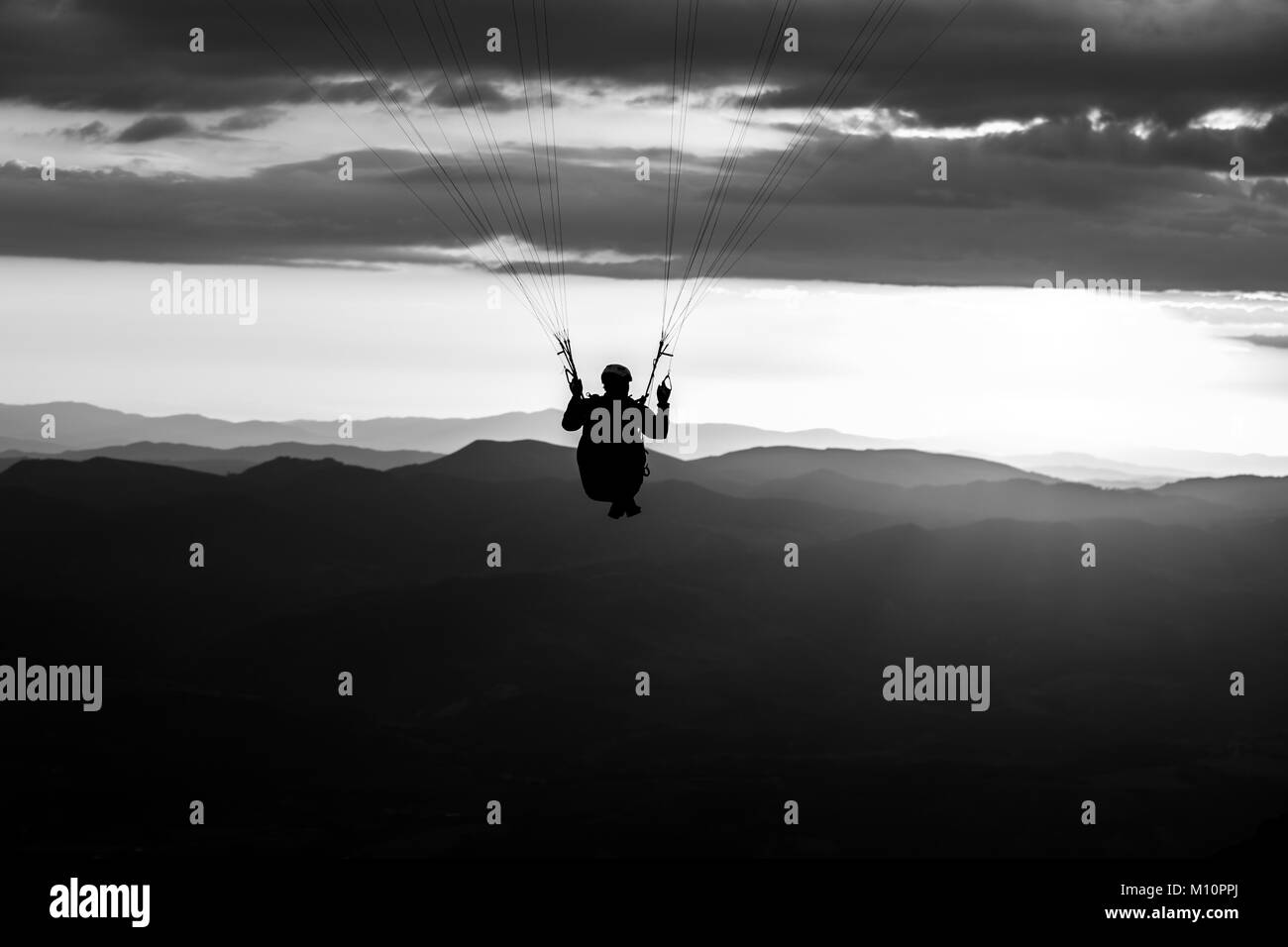 Bellissimo colpo di un parapendio silhouette volando sul Monte Cucco (Umbria, Italia) con il tramonto sullo sfondo Foto Stock