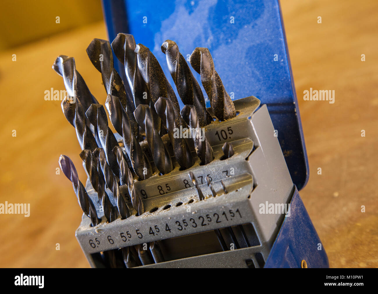 Una scatola di punte da trapano su un banco di lavoro, coperto di polvere di legno, segatura, trucioli, Foto Stock