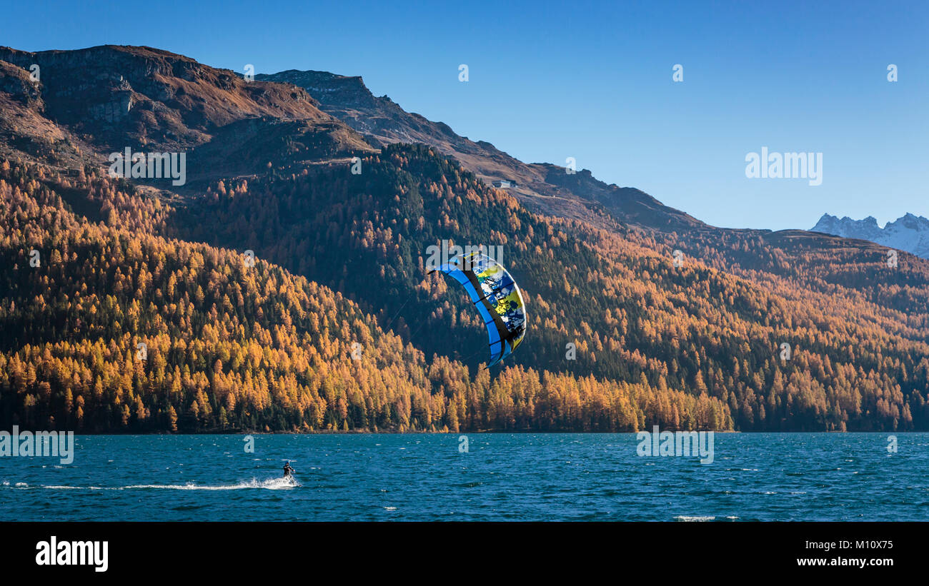 Wind surf sul lago di Silvaplana con la caduta delle foglie colore in larice alberi in Engadina, Graubuden, Svizzera, Europa. Foto Stock