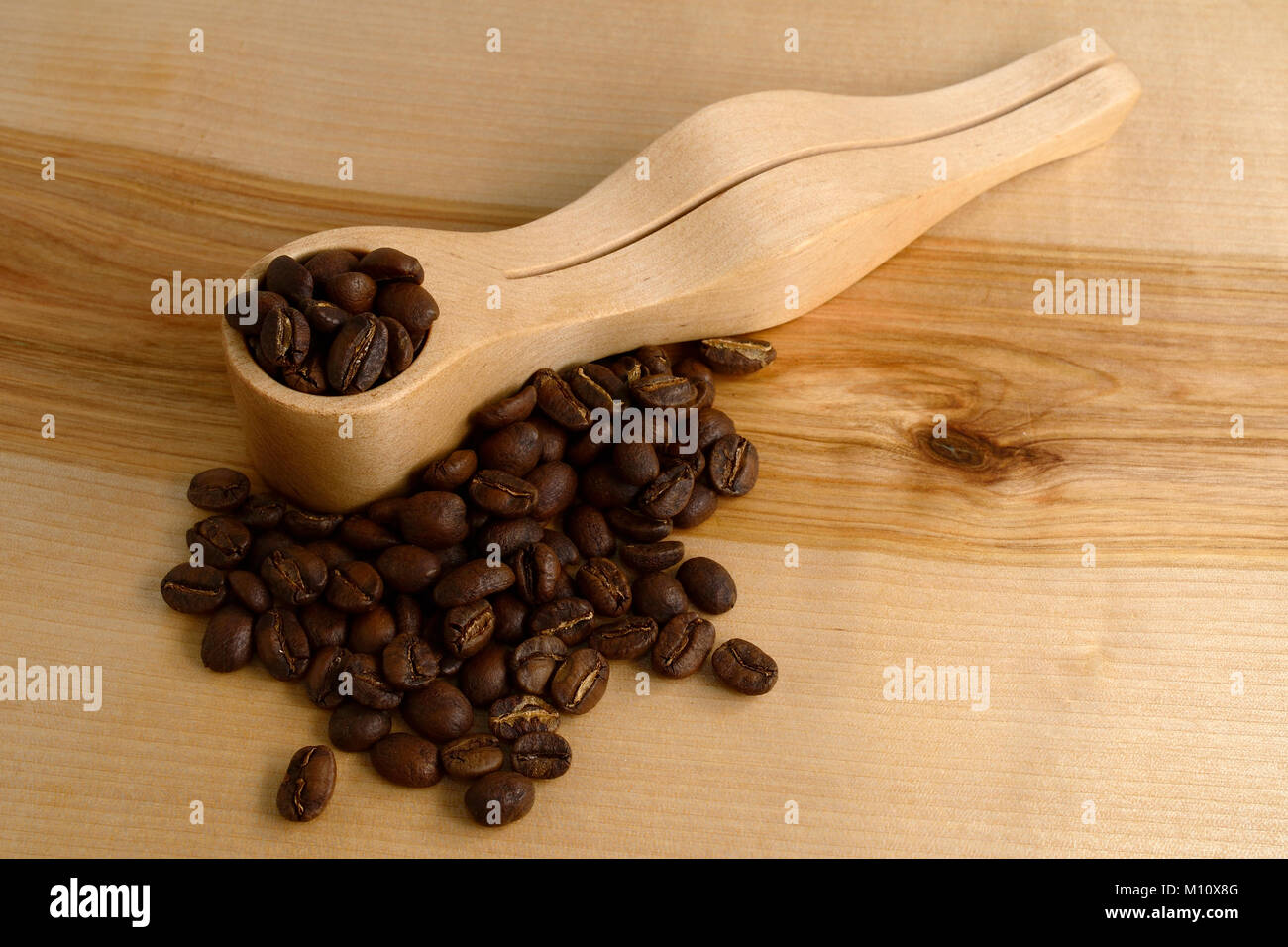 Caffè misurino e chicchi di caffè su una superficie in legno Foto Stock
