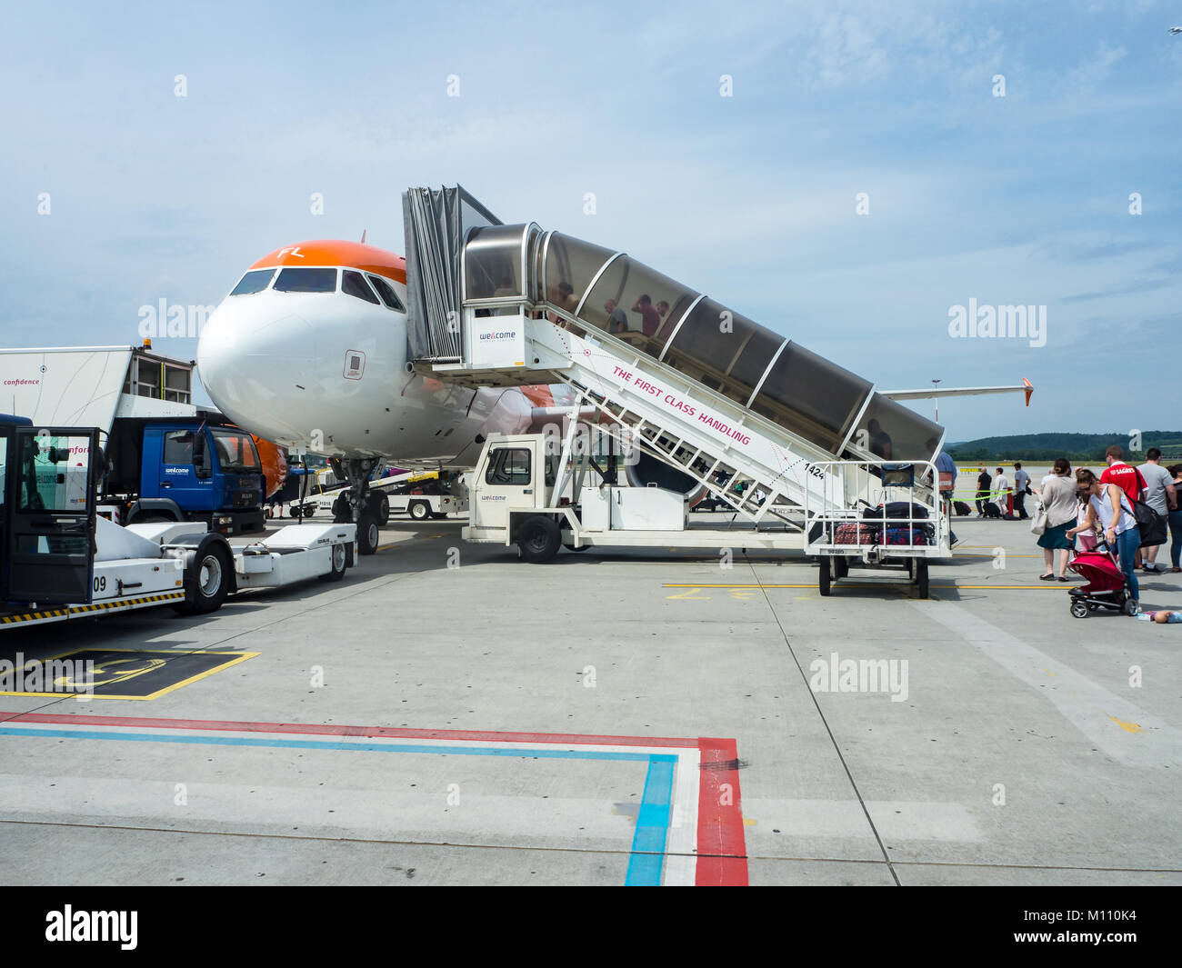 Cracovia in Polonia - Giugno 27, 2017: veicolo di scale e ai passeggeri di salire a bordo di un Airbus A320 aereo di linea su Balice Aeroporto Internazionale di Cracovia Foto Stock