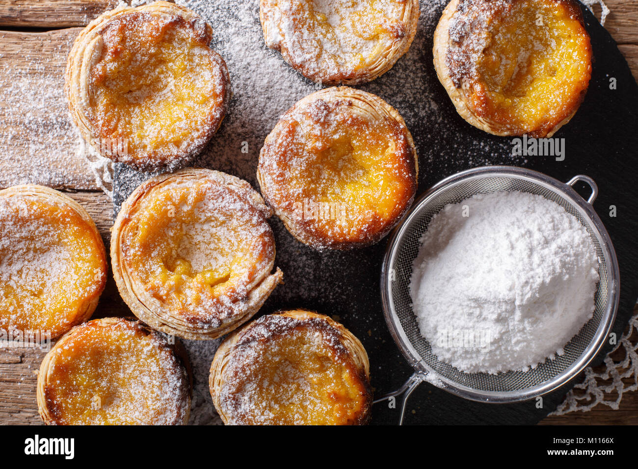 Deliziosi dolci Pastel de nata con crema pasticcera vicino sul tavolo. parte superiore orizzontale vista da sopra Foto Stock