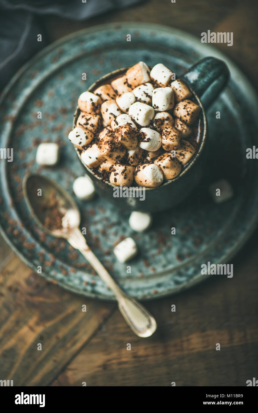 Riscaldamento invernale dolce bere cioccolata calda con marshmallows e cacao in tazza su sfondo di legno, fuoco selettivo Foto Stock