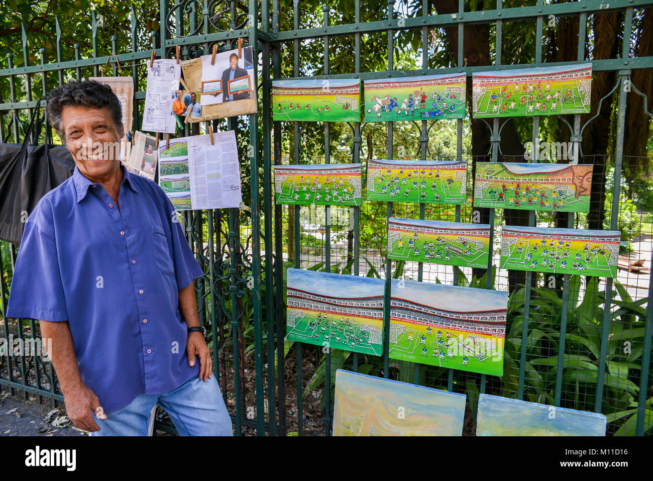 Manoel Francisco Lopes de Faria accanto ai suoi dipinti raffiguranti momenti iconici di brasiliani e internazionali di calcio, Belo Horizonte, Minas Gerais Foto Stock