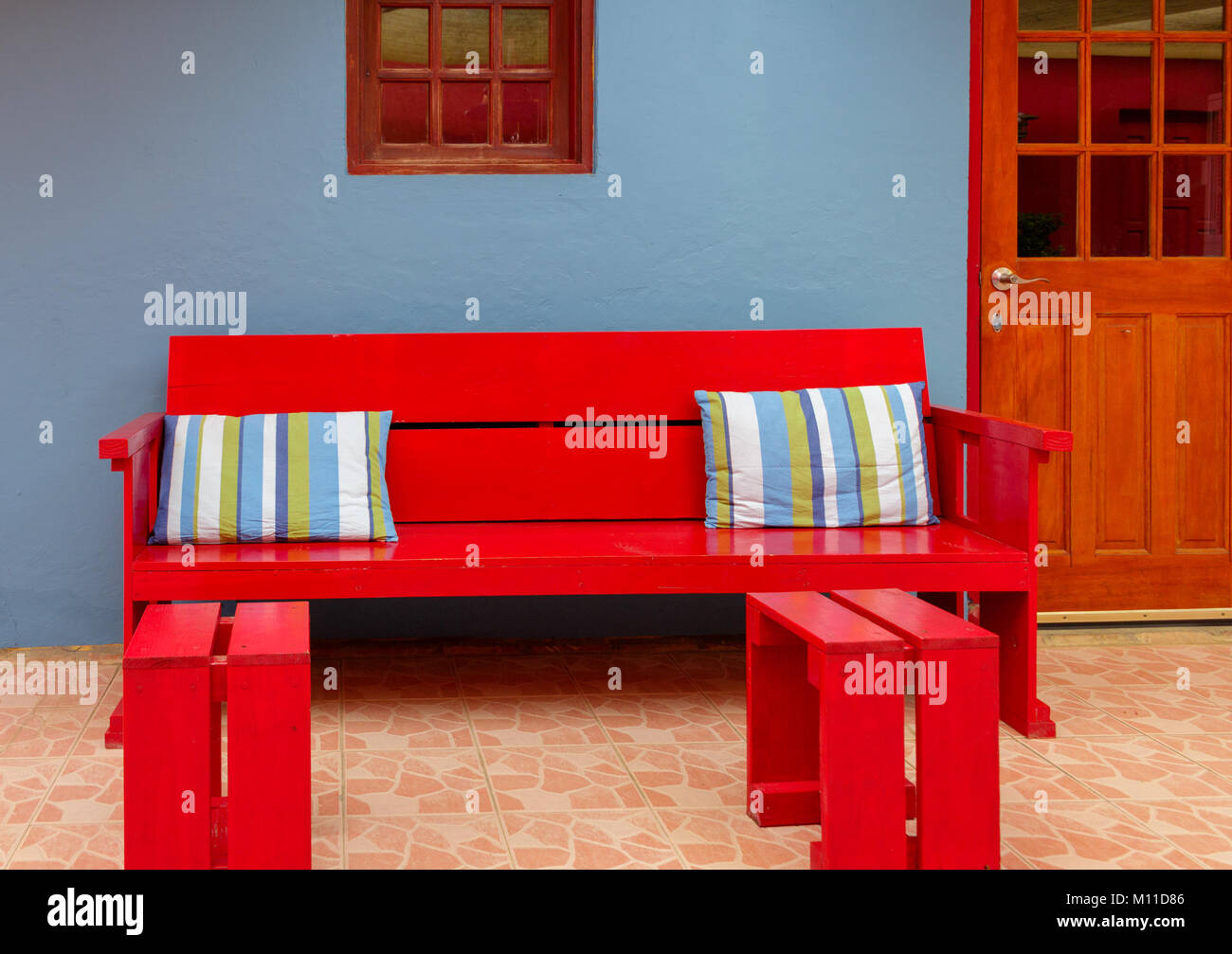 Cuscini colorati in rosso banco in legno Foto Stock