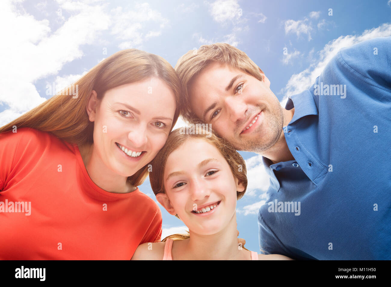 Ritratto di famiglia felice contro il cielo nuvoloso Foto Stock