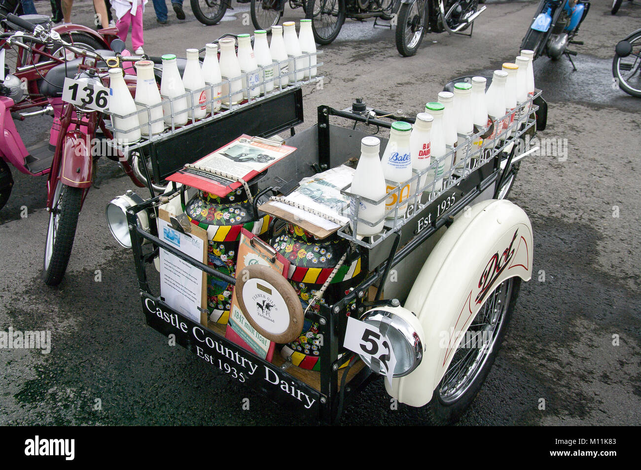 Bottiglia di latte di consegna da parte di paese Castello Latteria di tempi passati trasportati da uno specialista atto Dot motociclo in mostra nel Regno Unito Foto Stock
