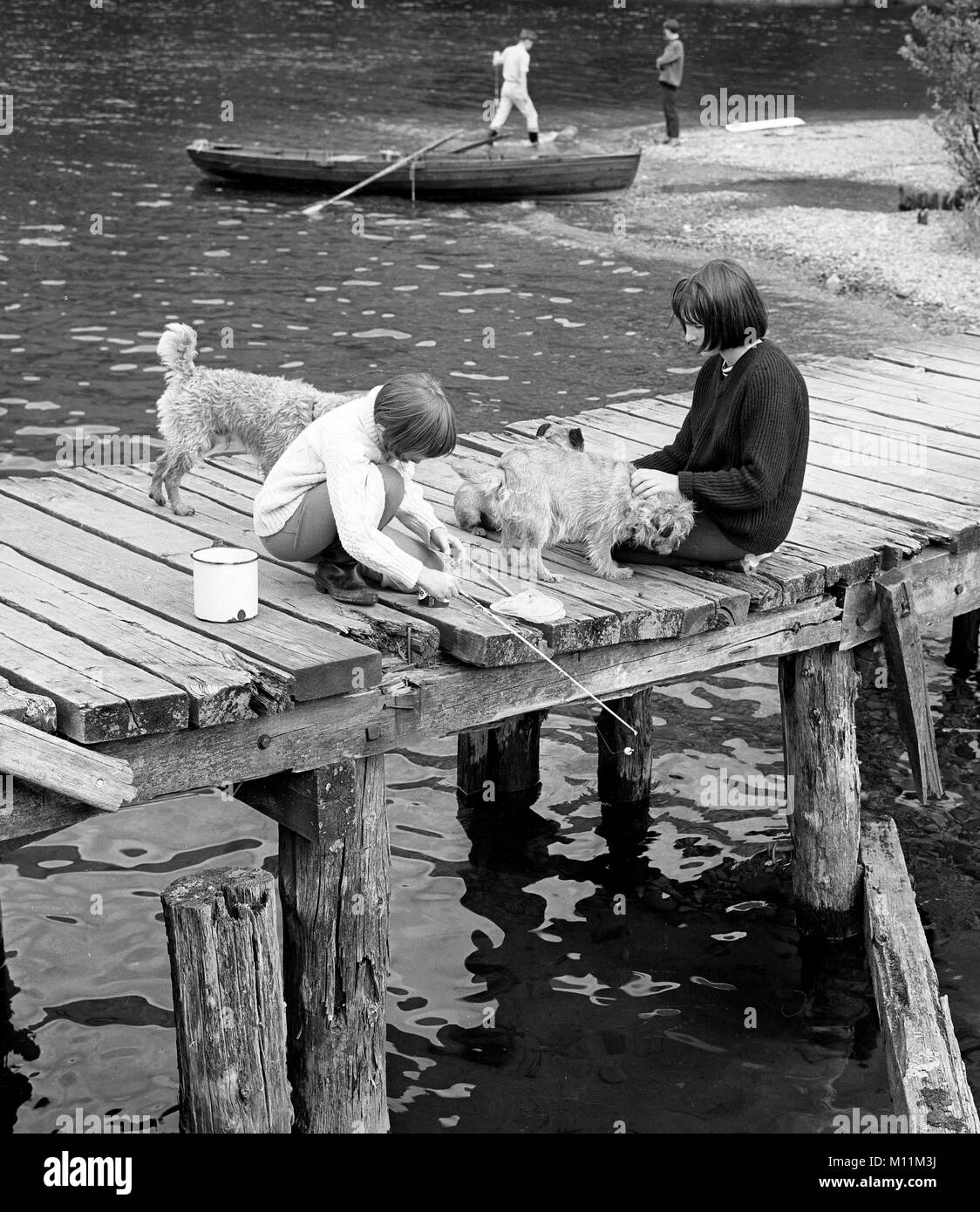 Bambini che giocano la pesca sul molo Gran Bretagna 1960 Foto Stock