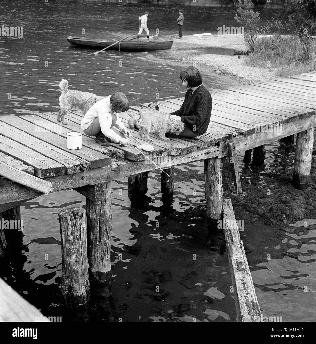 Bambini che giocano la pesca sul molo Gran Bretagna 1960 Foto Stock