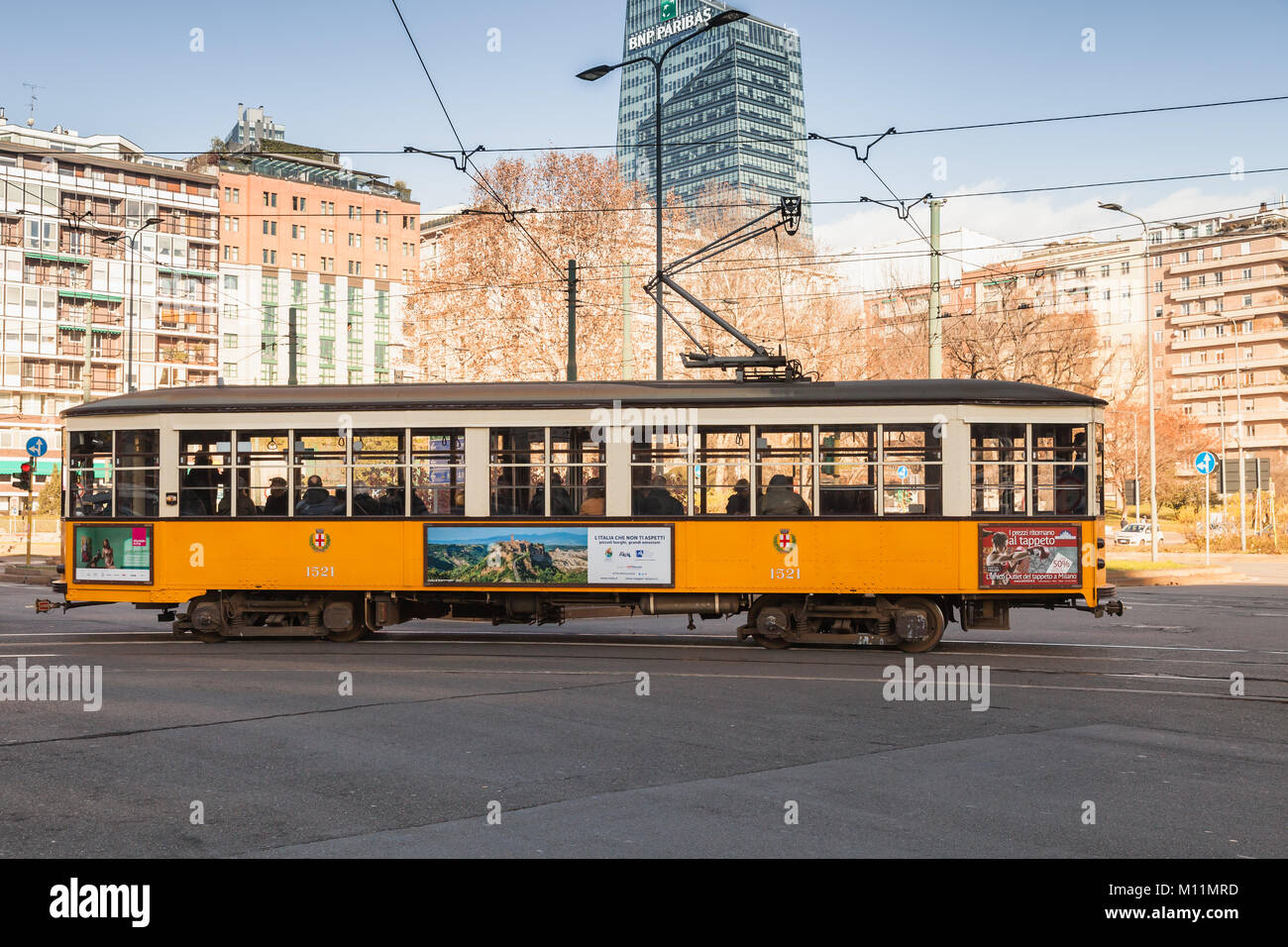 Milano, Italia - 19 Gennaio 2018: tram giallo con i normali passeggeri va sulla strada a Milano, vista laterale Foto Stock