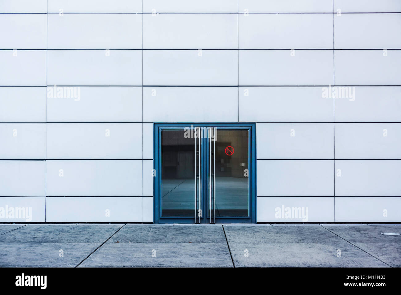 Una doppia porta di vetro su una parete bianca, Francia. Foto Stock