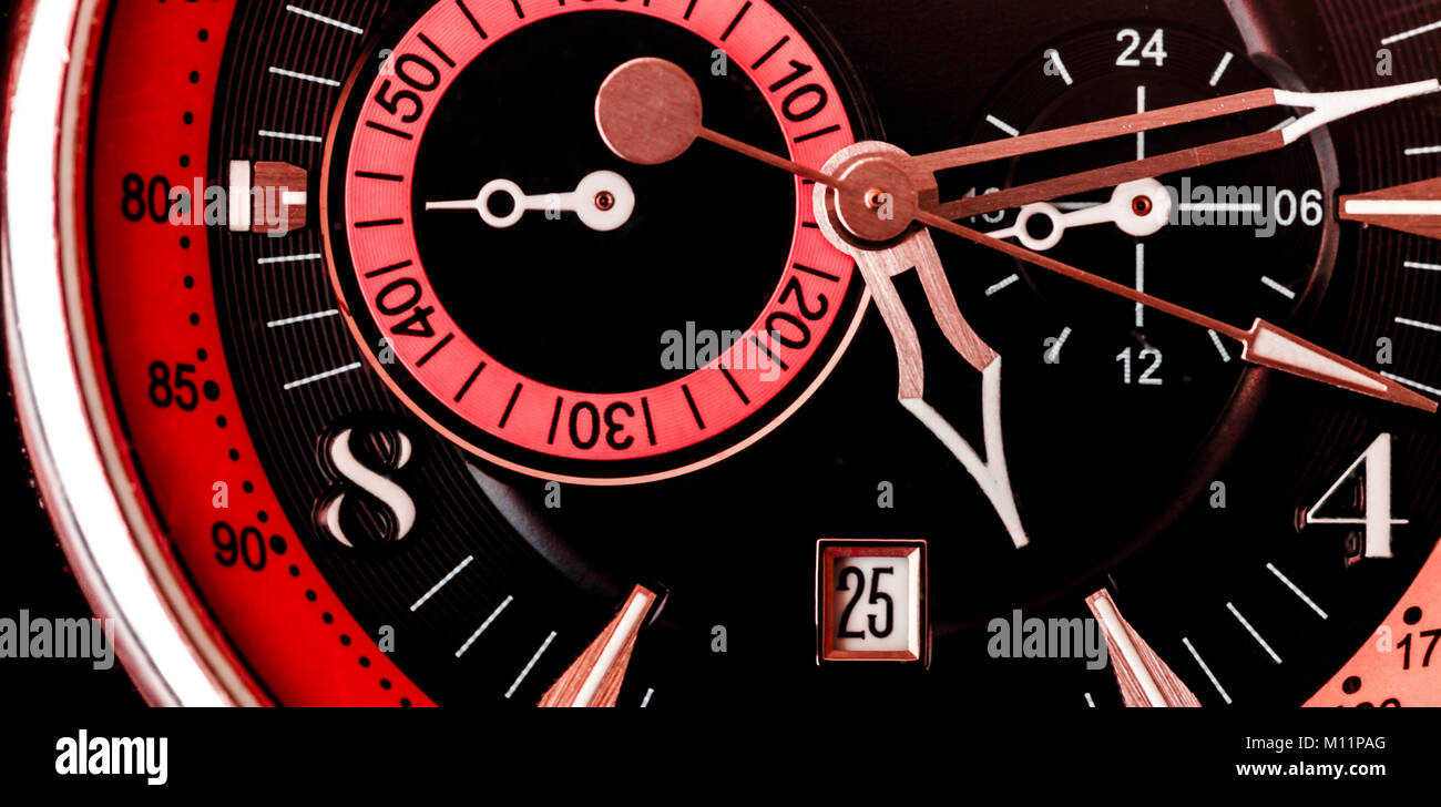 Extreme ravvicinata di un orologio da polso faccia/ meccanica con sfondo nero e rosso e rosa Foto Stock