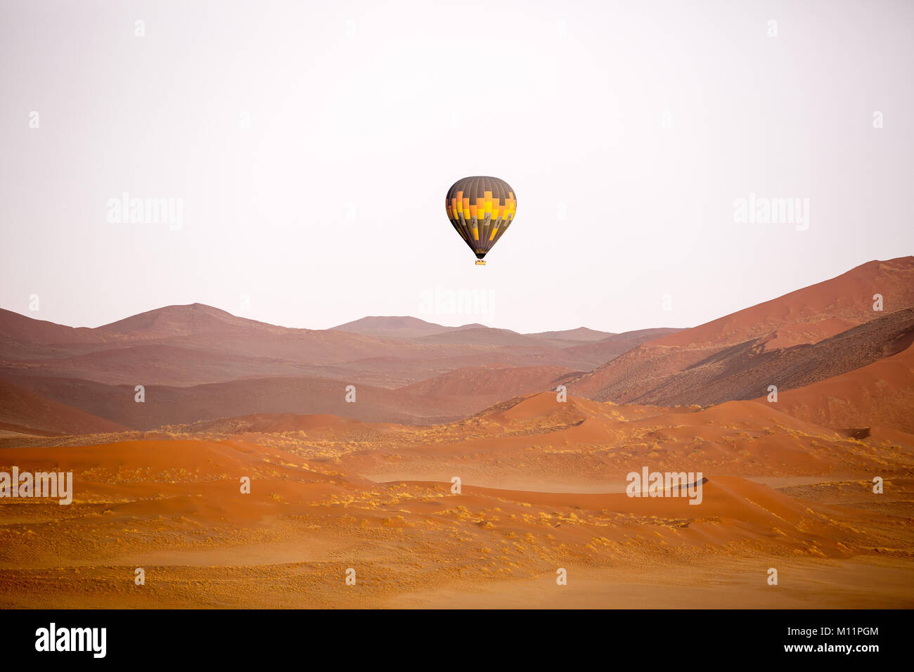 Una mongolfiera in volo sopra le dune di sabbia in Namibia Foto Stock