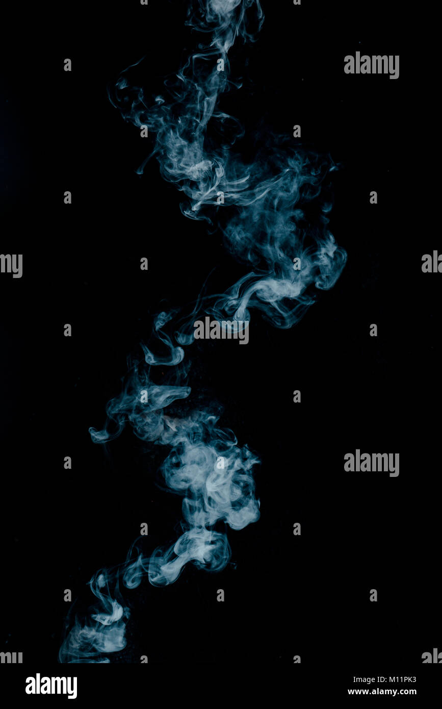 Texture di vapore da una bevanda calda su uno sfondo nero. Fumo blu con copia spazio. Foto Stock