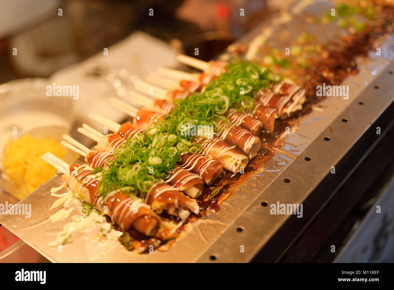Giapponese street food Hashimaki, Okonomiyaki laminati sulle bacchette, su una strada di mercato alimentare di stallo in Kyoto, Giappone Foto Stock