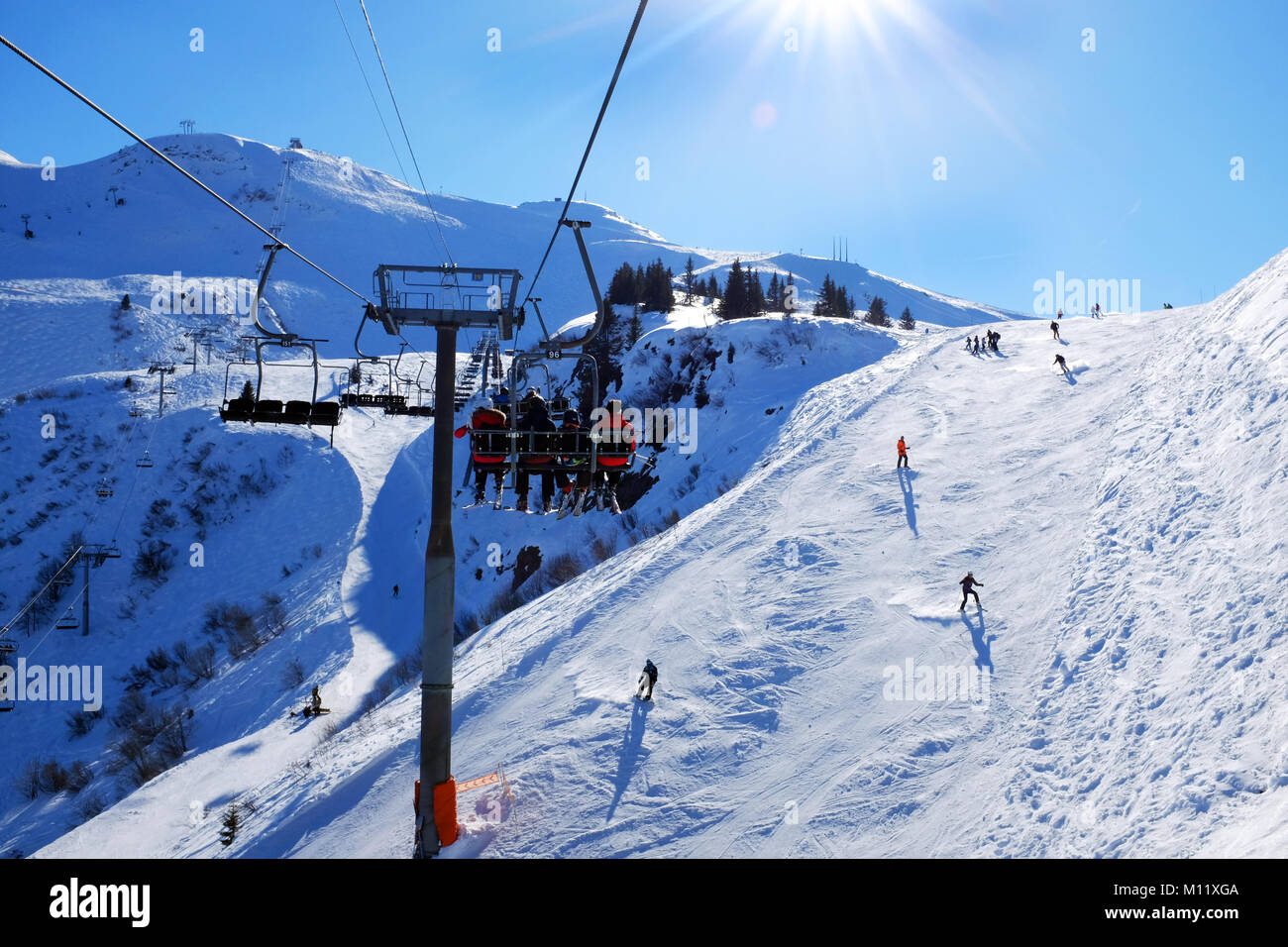 Vista di sciatori dalla seggiovia su un soleggiato tracciato di sci Samoens Francia Foto Stock