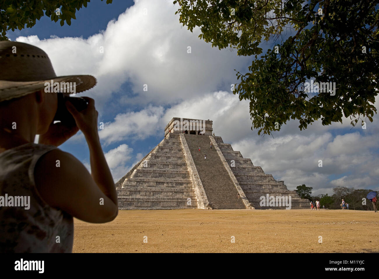 Messico. Yucatan. Chichen Itza. Rovine Maya. Rovine Maya-Toltec, El Castillo. Turista femminile prendendo foto della piramide. Foto Stock