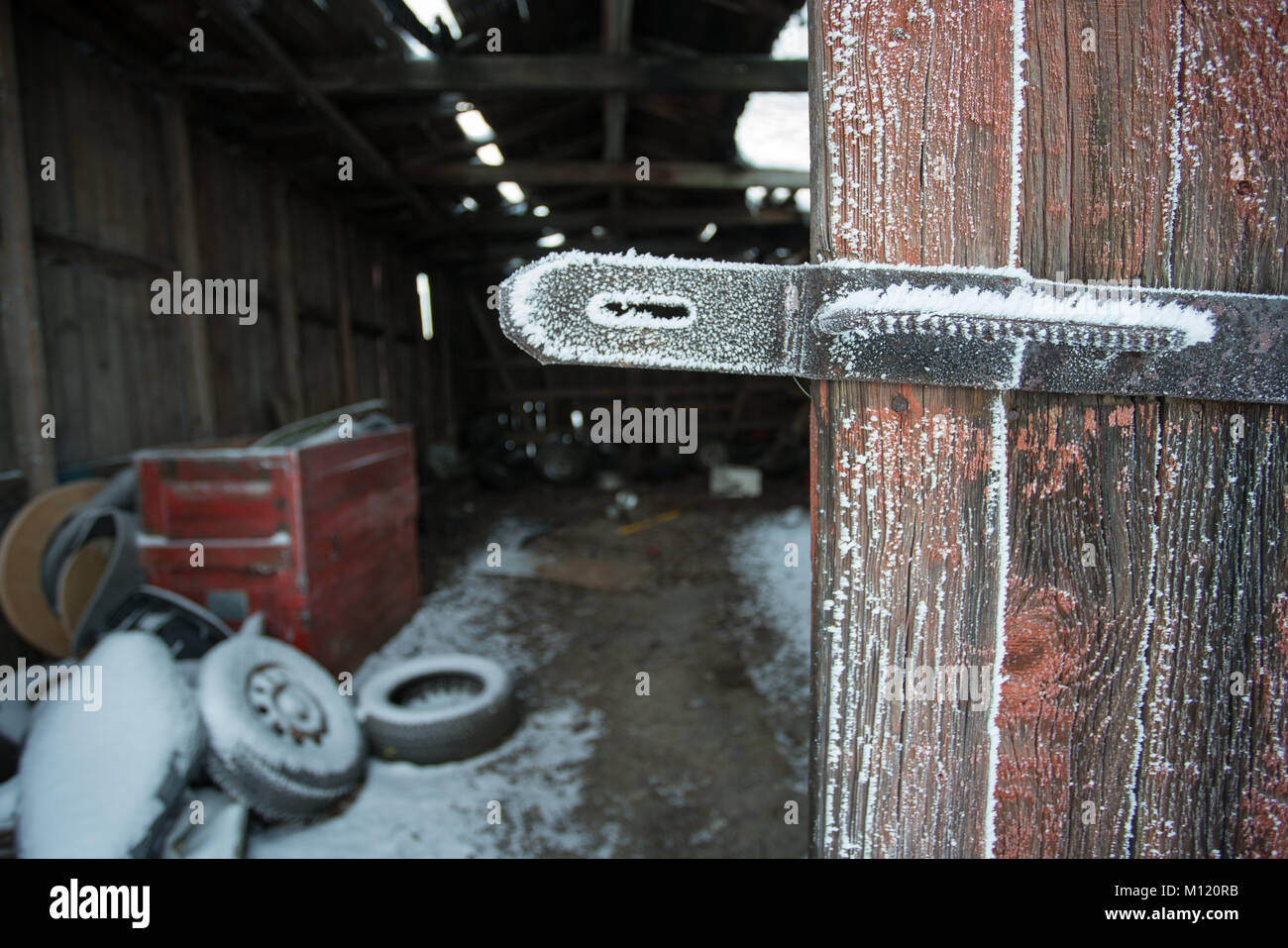 Vecchio e porta a spiovente portalucchetto ricoperto dal gelo con il vecchio garage abbandonati in background Foto Stock