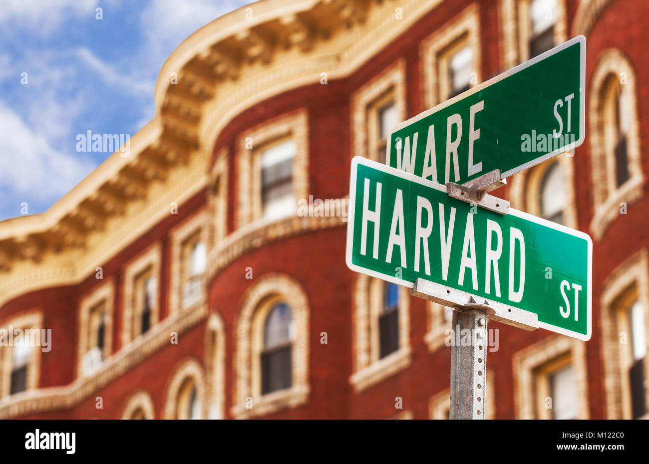 Harvard strada segno di Cambridge, Massachusetts, casa dell'Università di Harvard. Messa a fuoco selettiva in primo piano segno, tipico edificio di mattoni rossi dietro Foto Stock