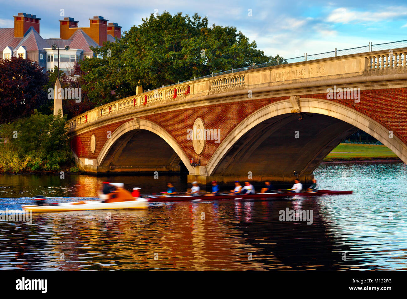 Università di Harvard team sculling mattina presto pratica. Battello passa sotto un ponte sul fiume Charles e a Cambridge, Massachusetts. Motion Blur. Foto Stock