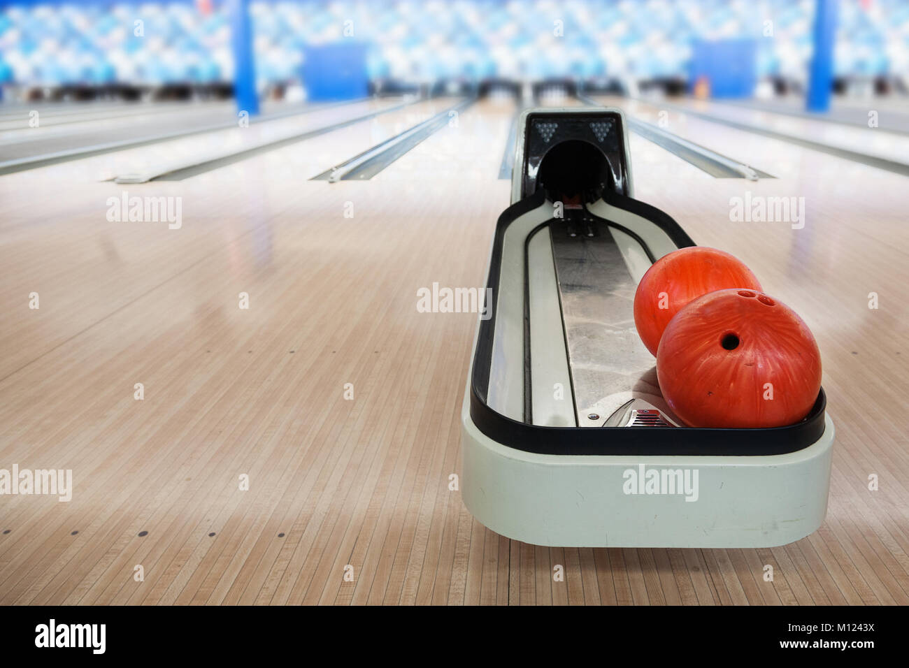 La messa a fuoco in primo piano bowling automatizzate per il ritorno della palla con macchina deliberata sfondo morbido pista da bowling e una copia dello spazio. Foto Stock