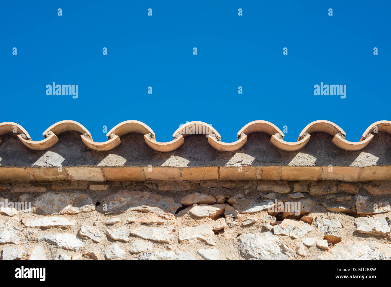 Dettaglio di argilla tegole del tetto da un paese mediterraneo casa in una giornata di sole. Foto Stock