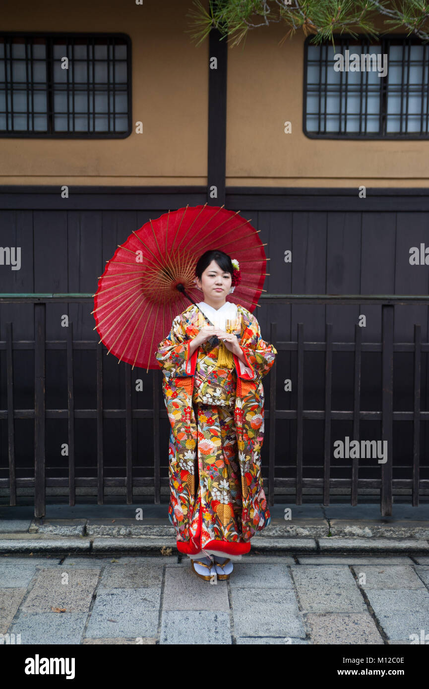 25.12.2017, Kyoto, Giappone, Asia - una giovane donna che indossa un kimono tradizionali comporta per un ritratto nella vecchia città di Kyoto. Foto Stock