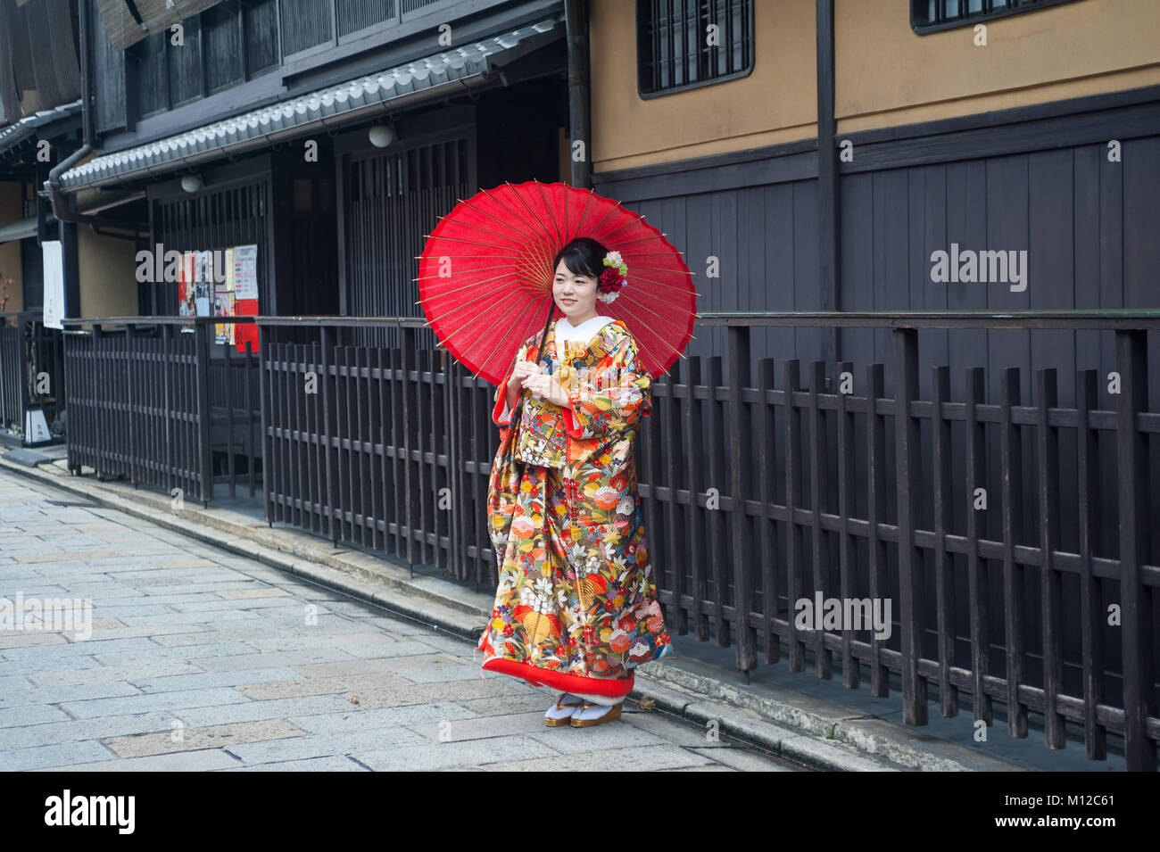 25.12.2017, Kyoto, Giappone, Asia - una giovane donna che indossa un kimono tradizionali comporta per un ritratto nella vecchia città di Kyoto. Foto Stock