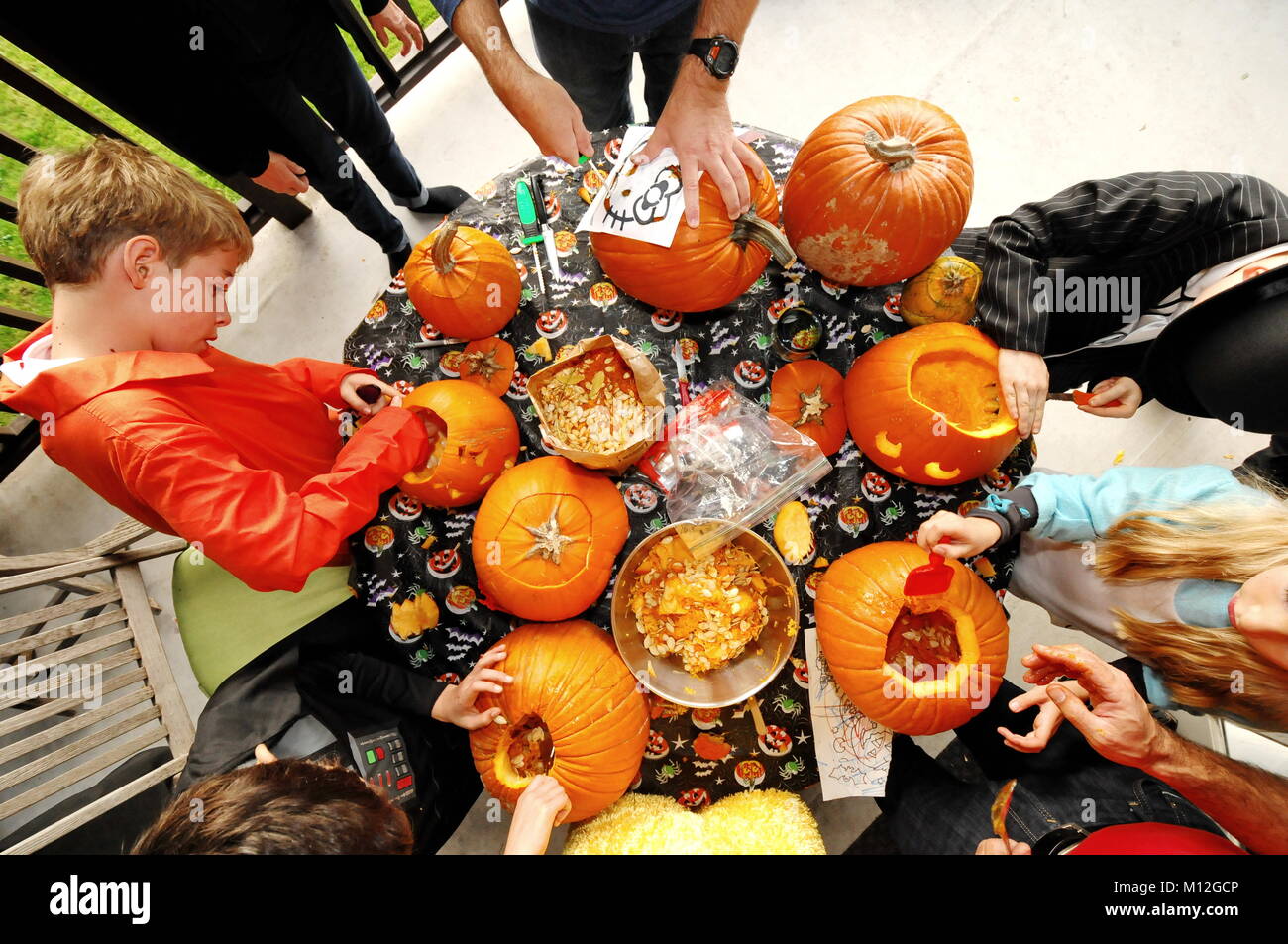 Vista aerea del carving kids zucche. Bella scena arancione. Halloween preparativi in corso. Foto Stock