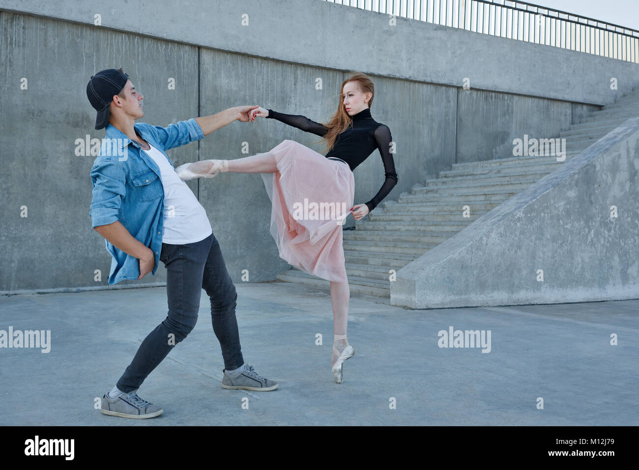 Un esile ballerina danze con un ballerino di danza moderna. Data di amanti. Prestazioni per le strade della città. Foto Stock