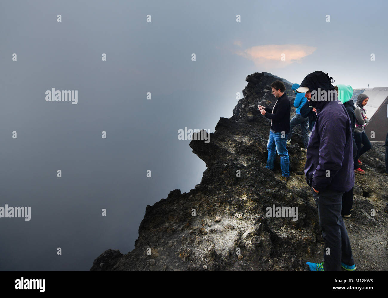 Gli escursionisti che guarda theNyiragongo cratere del vulcano nelle montagne Virunga, D.R.C Foto Stock