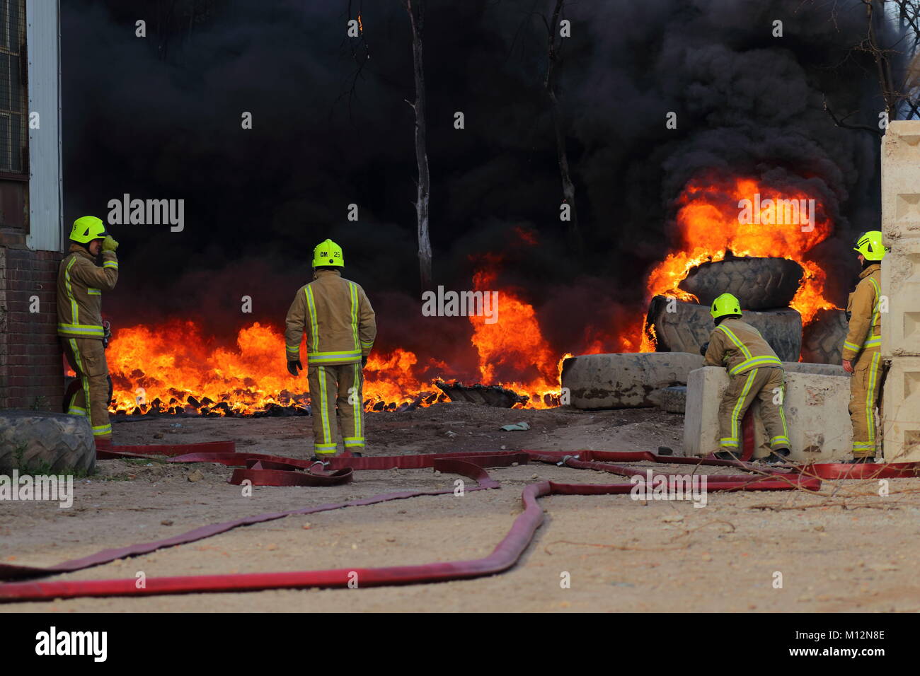 I vigili del fuoco di attendere per un approvvigionamento di acqua in modo che possano cominciare ad affrontare un incendio in Beeston,Leeds, West Yorkshire Foto Stock