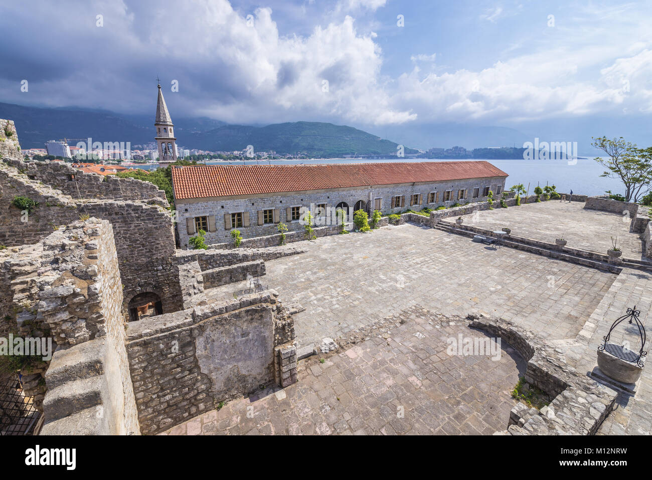 Sul tetto della cittadella, la città vecchia di Budva città sul mare Adriatico costa in Montenegro. Vista con il campanile di San Giovanni Battista cattedrale Foto Stock